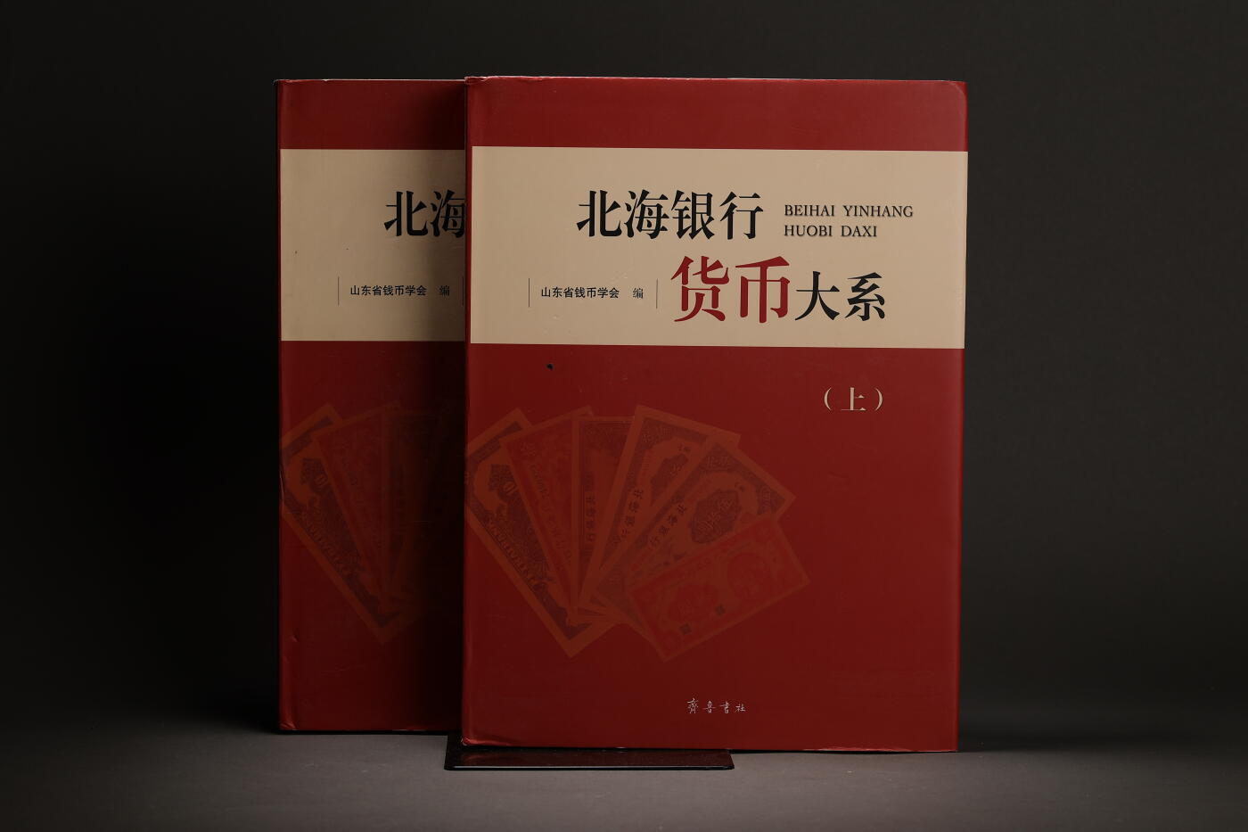 泓盛2025年秋季拍卖会 纸币 2015年《北海银行货币大系》上下册一套，山东省钱币学会编，全彩色908页，内中收录北海银行流通票版式300余种、票样180余种，几近囊括所有目前已发现的北海币品种，并以大量文字介绍，图文并茂，乃集藏北海银行纸币之圣典，值得重视与推介，全新完好