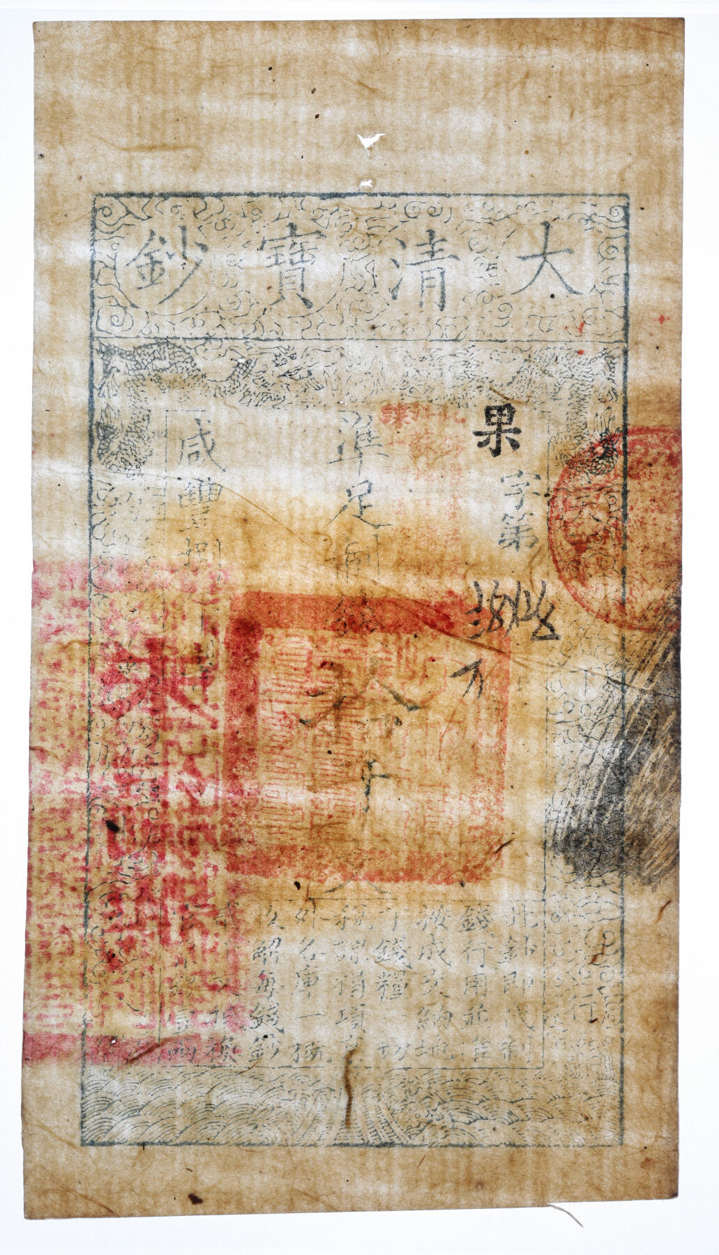 泓盛2025年秋季拍卖会 纸币 咸丰柒年（1857年）大清宝钞拾千文，果字号，此字号存世罕见，加盖有“此钞准商民交纳江苏地丁关税盐课一切正杂钱粮”，左边钤有“江南河道总督关防”，背盖“未编号”红字，纸张厚实，色彩浓郁，醇厚自然，八五成新（严重低评，荒唐可笑，PMG-30/2338542-113）