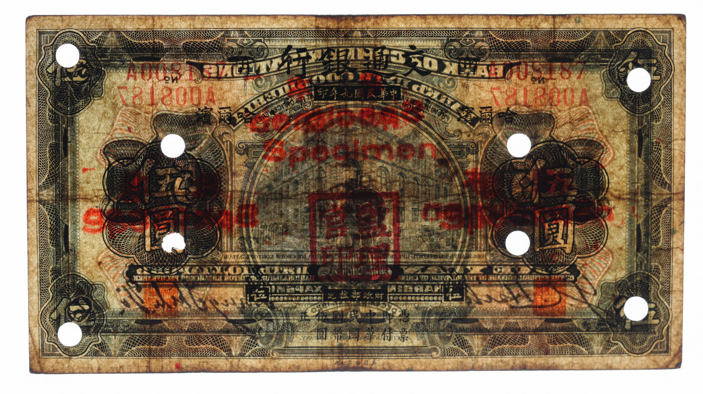 泓盛2025年秋季拍卖会 纸币 民国九年（1920年）交通银行伍圆，正票改作样本，哈尔滨地名，无字轨，少见，盖“监理官印”，梁士诒·谢荫昌签名，背印俄文；纸张厚实硬挺，色彩浓郁醇厚，原汁原味，八成新（严重低评，PCGS-25/89529458）