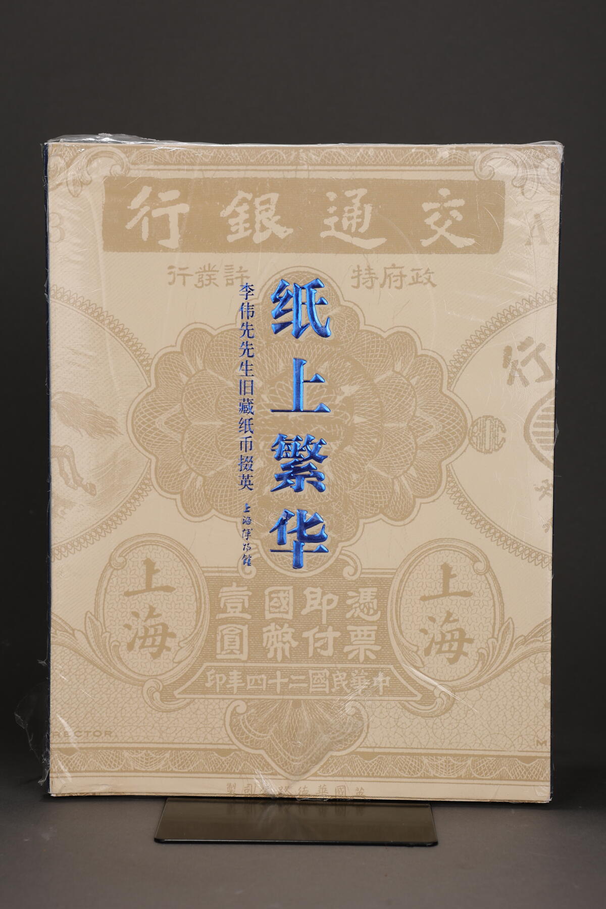 泓盛2025年秋季拍卖会 纸币 2012年上海博物馆编《纸上繁华·李伟先旧藏纸币掇英》，上下册带封套，大16开全彩色共厚709页，内中为40年代集钞名家李伟先氏生前捐赠给上海博物馆之藏品精选，乃一代宗师成就与品德之完美体现，堪称令人赞赏的中国纸币经典著作，全新