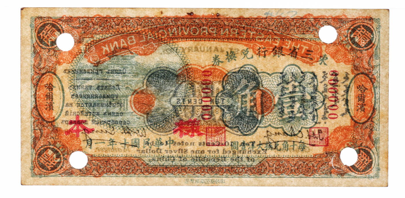 泓盛2025年秋季拍卖会 纸币 民国十年（1921年）东三省银行兑换券壹角样本，哈尔滨地名，第一版深色券，背印蒙、俄文字，为“征蒙”专用而发行，实心小“样本”字，纸张厚实硬挺，纹理清晰，色彩浓郁醇厚，原汁原味，有订书孔，九八成新（严重低评，唯一殿军分、更高分仅3枚，PMG-55/2212898-010）