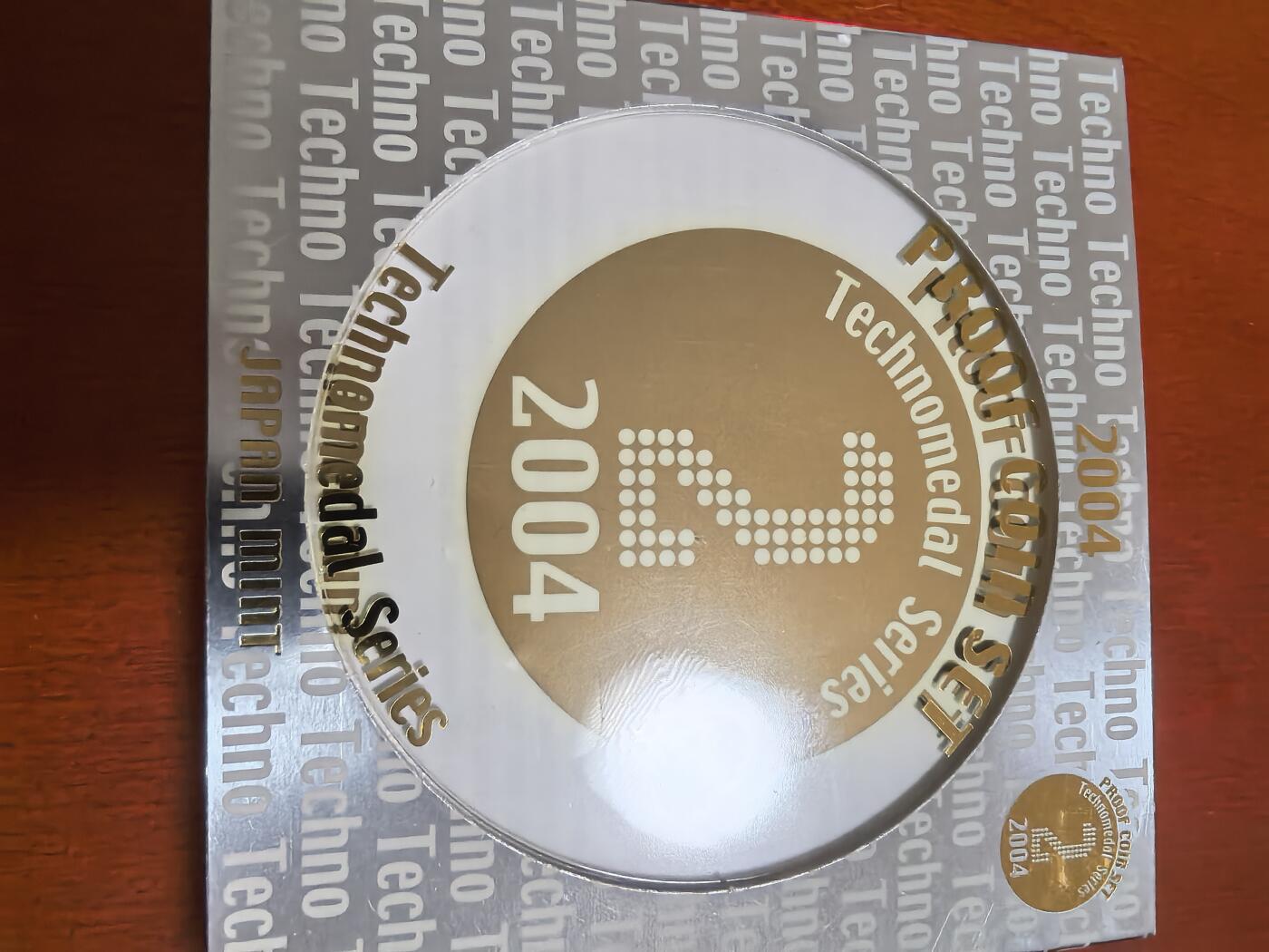 长老汇蛇年精选第六十二场拍卖 2004日本科技系列之二6枚精制币套装小方盒，含银质梅花形镀金银章1枚，难得带外纸盒