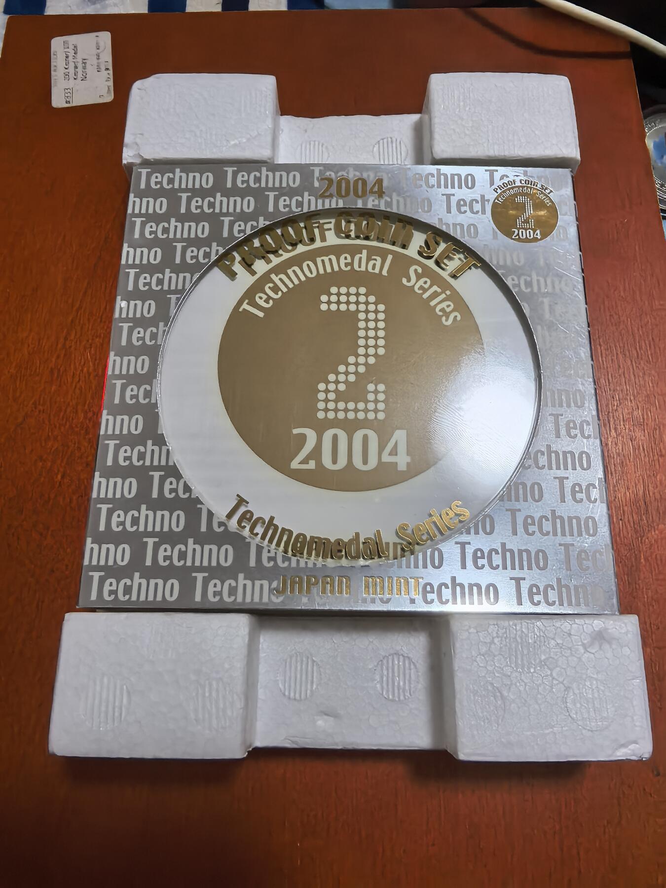 长老汇蛇年精选第六十二场拍卖 2004日本科技系列之二6枚精制币套装小方盒，含银质梅花形镀金银章1枚，难得带外纸盒