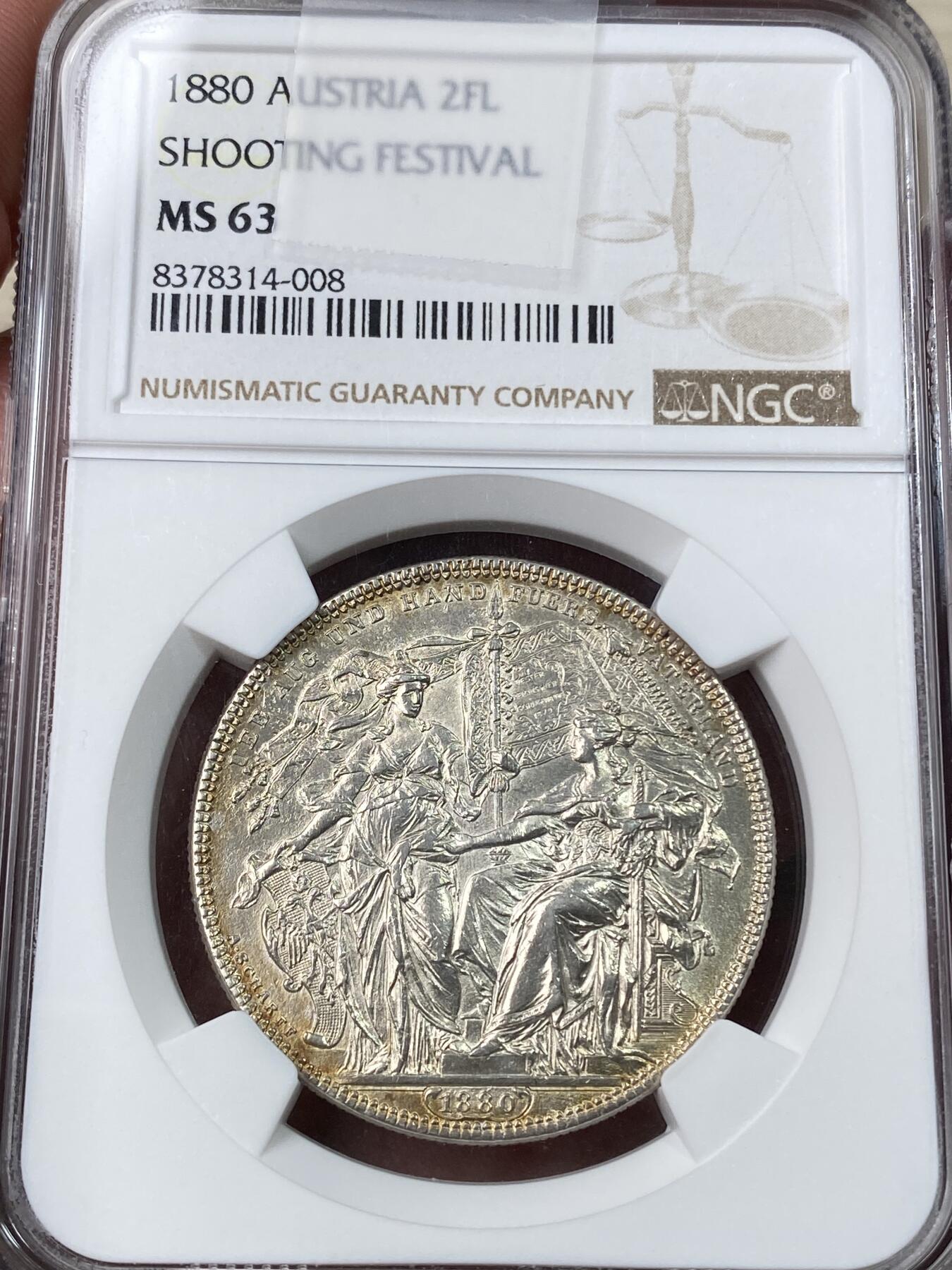 万国钱币拍卖第053期【万国秋季大拍上●周五周六两场连拍】 NGC MS63 1880年奥地利射击节2弗罗林大银 沙夫名作 奥射名品之一 币章中的贵族 淡金彩环绕