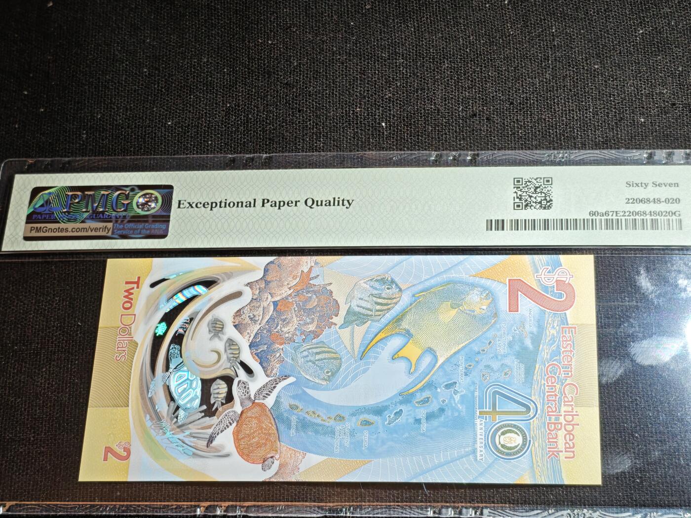 刘世昌艺术品销售中心～虎踞龙蟠*金杨在线联拍群第507期  东加勒比2023年“央行成立40周年”2元纪念钞（PMG 67E 号码：AB205905）1枚。此币荣获当年IBNS世界纸币大奖赛“最佳纸币”大奖。