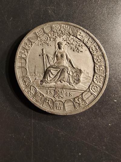 老王徽章第157期 - 德国1848年法兰克福国民议会纪念章     该章纪念的是1848年5月18日在美茵河畔法兰克福开幕的第一次德意志国民议会。 议会是在1848年革命期间成立的，旨在为德意志各邦起草一部统一的宪法。 章上刻有（我们是一个民族，我们愿意团结行动）的字样       直径42mm.  重量27.7g