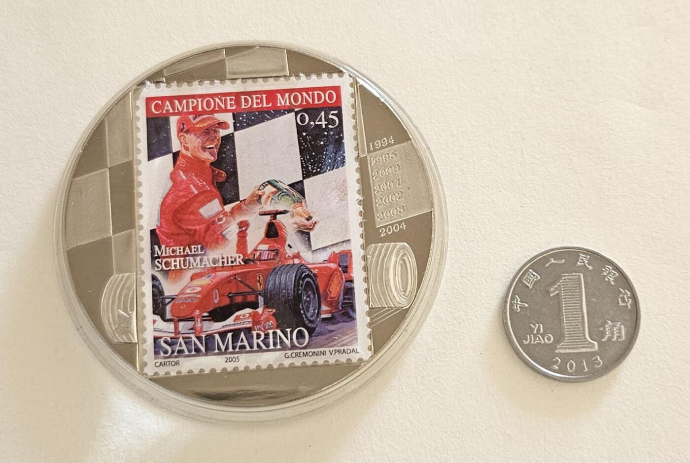 【币将精彩】世界钱币拍卖（2025-11-5） 刚果2007年F1车王舒马赫彩色精制镶圣马力诺邮票纪念铜镍币  币中票，直径50毫米