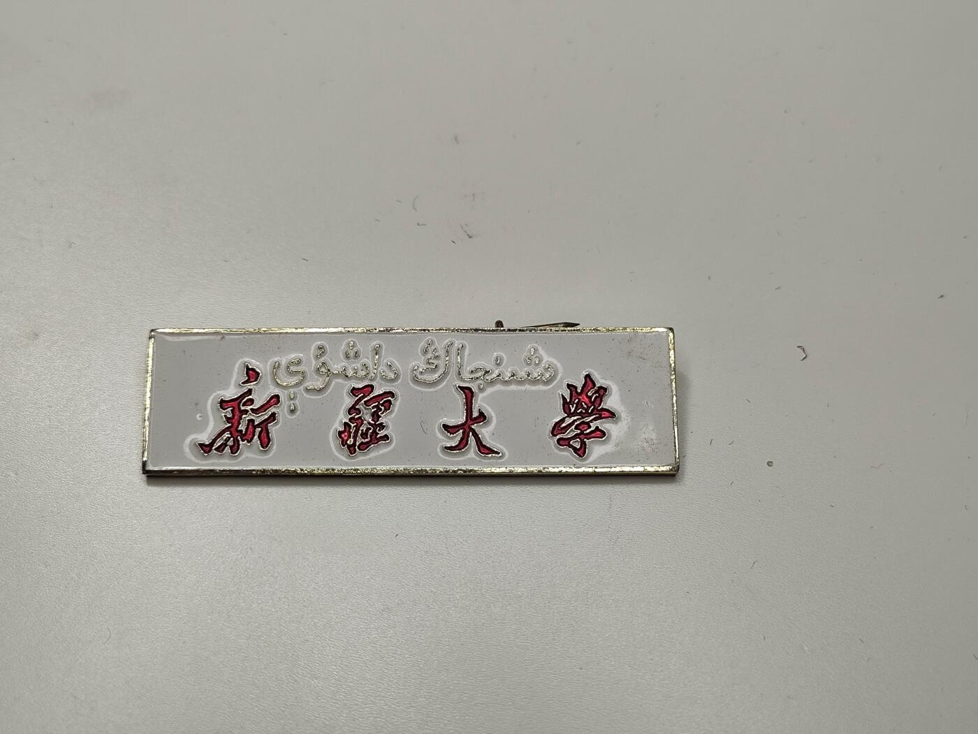 新时代收藏徽章红藏拍卖(第二十七场)  徽章纸品证书杂项 60年代 新疆大学证章 双语维文背后带编号