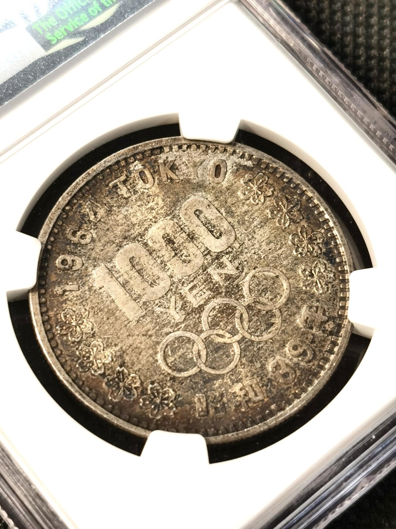 甄臻铺-世界币章拍卖（第36期），送拍享返佣金等优惠多多 NGC-MS62日本1964年东京奥运1000元银币 酱彩