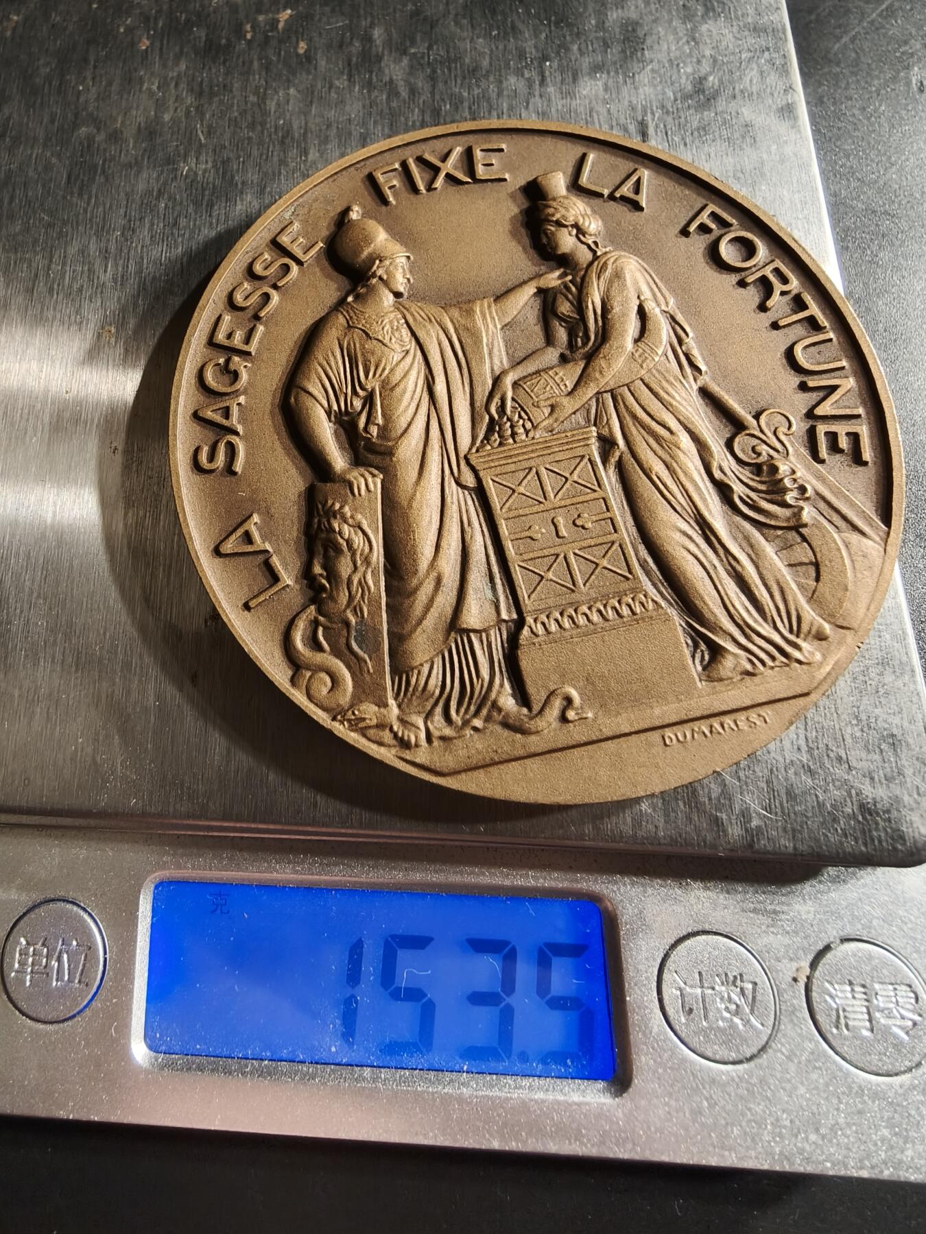 老王徽章第158期 法国法兰西银行150周年大铜章     直径68mm.   重量153.5g.    背面为密涅瓦与福图娜，与格言智慧固定财富相合   高浮雕设计   Dumarest作品