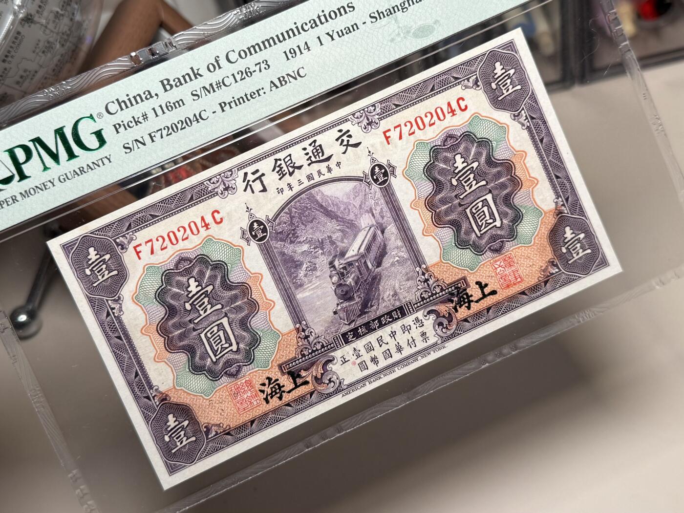 【乾奕收藏】出民国3年1914年交通银行上海地名壹圆，紫火车图案，PMG65E，稀少热门品种，民国纸币经过80年能保存如此品相实属难得，喜欢的老板不要错过，评级币一切以分数为准，售出非假不退