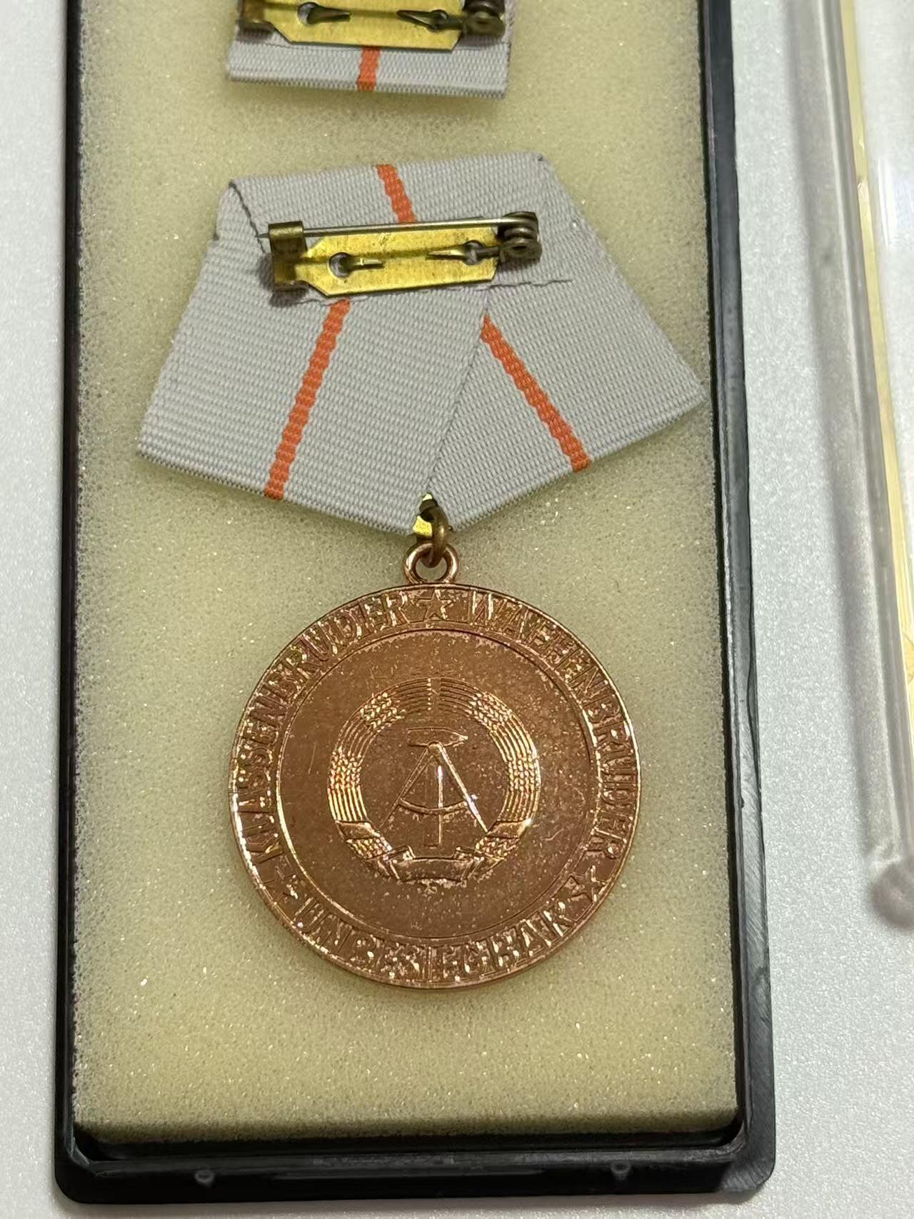 韵星假日精品2025秋季军品类拍卖会-- Rimey Holidays Boutique 2025 Autumn Militaria Sale 民主德国铜级巩固战斗友谊奖章带盒略 授予参与国际军事行动的军人和准军事组织成员