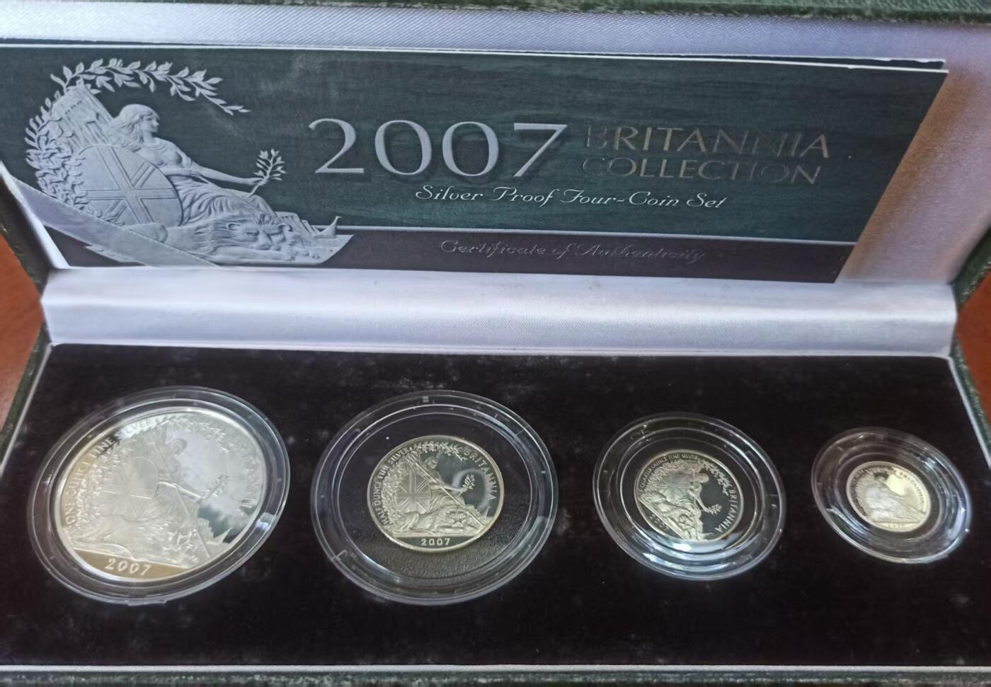 ❤️【币观天下】❤️ 第329期钱币拍卖- 2025.10.31周五晚上6点半场-长期征集拍品 英国2007年不列颠女神系列银币 英国自1997年开始发行不列颠女神系列盒装银币，规格统一，四枚一套自成系列。成色.958银，四枚的重量为32.454克、16.227克、8.114克、3.246克，即一盎司、半盎司、1/4盎司和1/10盎司。面值则为两镑、一镑、五十便士和二十便士。此套为该系列的第六套。图案设计为右手持三叉戟扶盾左手拿月桂枝，狮子匍匐在脚下的女神坐像。能在仅仅3克多的币面上将不列颠