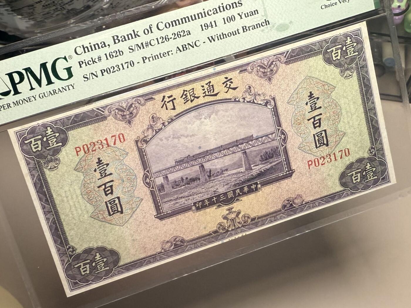 【乾奕收藏】出民国30年1941年交通银行美钞版壹百圆，行驶中火车和铁路桥图案，美国PMG35分，民国纸币经过80年能保存如此品相实属难得，喜欢的老板不要错过，评级币一切以分数为准，售出非假不退