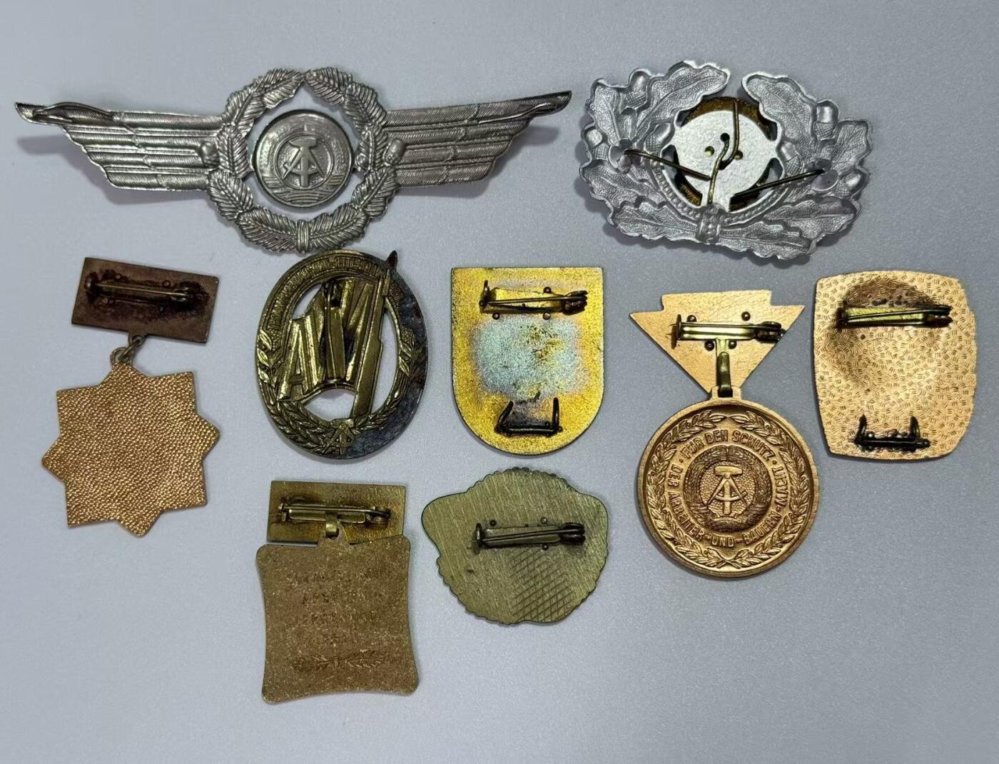 韵星假日精品2025秋季军品类拍卖会-- Rimey Holidays Boutique 2025 Autumn Militaria Sale 民主德国勋赏一组（准军事组织帽徽 空军帽徽 军版金级体能章 优秀士兵）