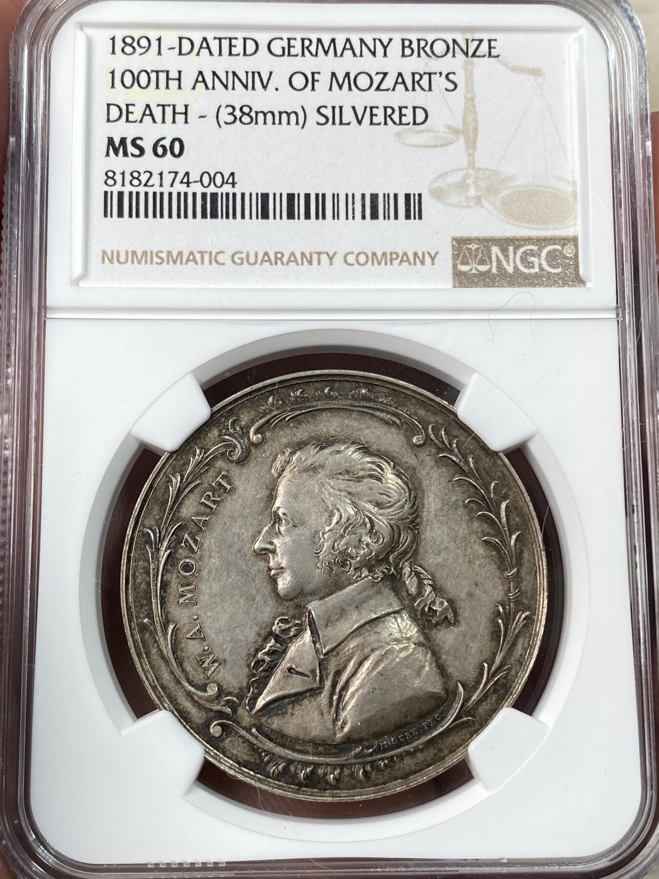 万国钱币拍卖第054期 NGC MS60 1891年德国莫扎特逝世100周年纪念镀银铜章 直径38毫米，正面是莫扎特侧身肖像，背面是竖琴和音符图案，周围环绕着