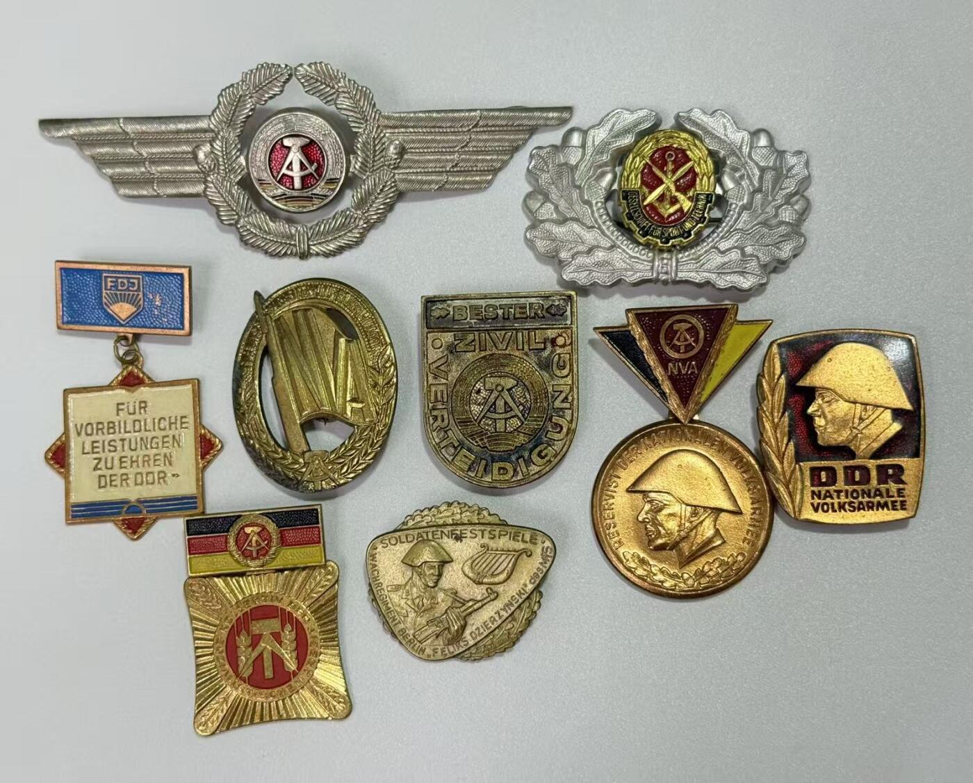 韵星假日精品2025秋季军品类拍卖会-- Rimey Holidays Boutique 2025 Autumn Militaria Sale 民主德国勋赏一组（准军事组织帽徽 空军帽徽 军版金级体能章 优秀士兵）