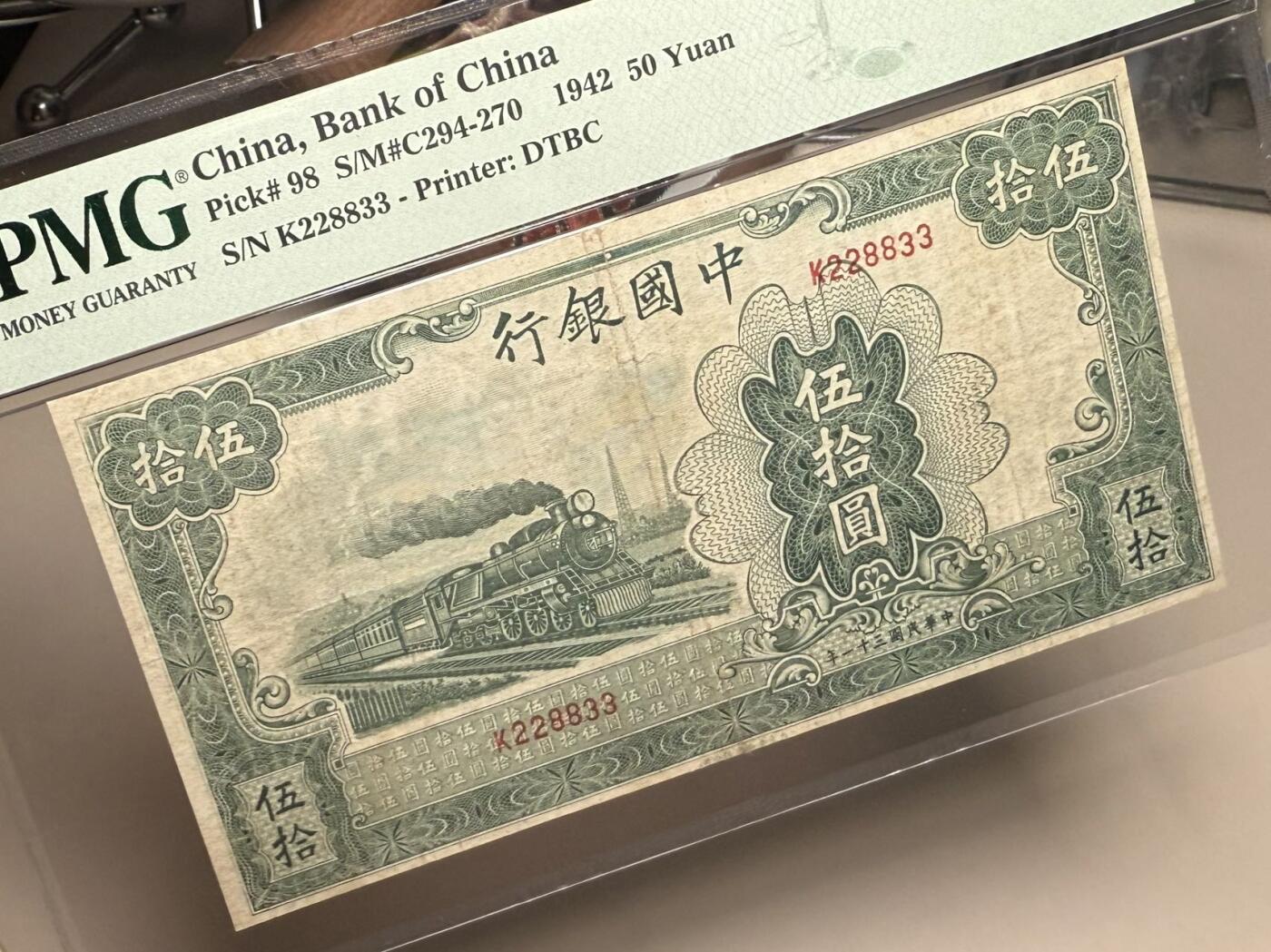 （自动截拍）PMG评级民国纸币专拍第20251115期，全场包邮 【乾奕收藏】出民国31年1942年中国银行大东版伍拾圆，大东三剑客之一，交行，中国银行，中国农民银行共用相同图案印刷，仅行名、签名和颜色不同，绿色火车图案。228833，三对子超级靓号，号码全程无47，美国PMG25分