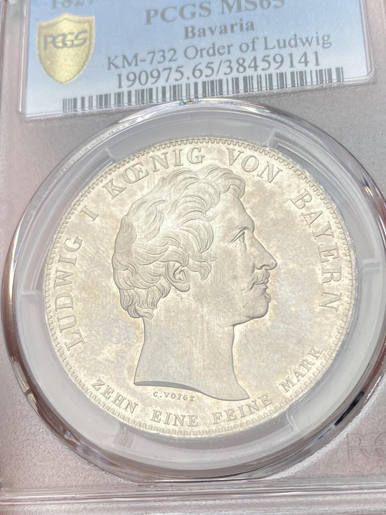 万国钱币拍卖第054期 PCGS MS65 1827巴伐利亚路德维希勋章历史泰勒 1827年8月25日，路德维希一世以国王之名设立了路德维希勋章，用以表彰为王国服务满50周年的杰出人员，并敕令造币厂发行此历史泰勒加以纪念。系列中的罕见品种，BU级别更是难得一见，丝绸地板黄油转光。（评级盒背面左上缺角）
