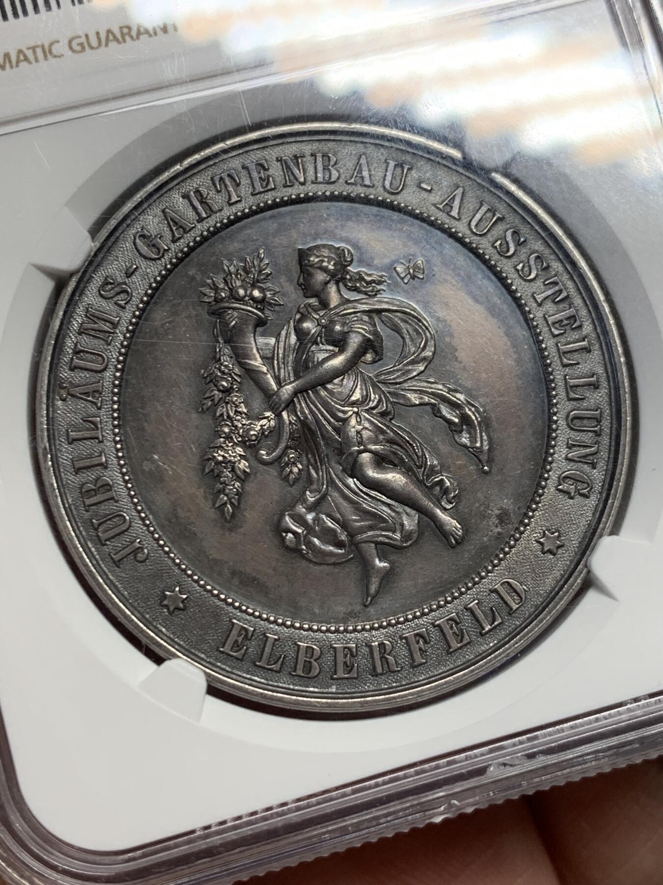 《竞宝斋》第434场 周日，周一2场连拍 （全场包邮） NGC MS61 德国1893年园艺博览会大银章，41mm大规格，少女衣纹流畅丰美，花卉蔬果刻画精细，工艺精湛。黑彩老包浆非常漂亮，实物状态极佳，严重低评