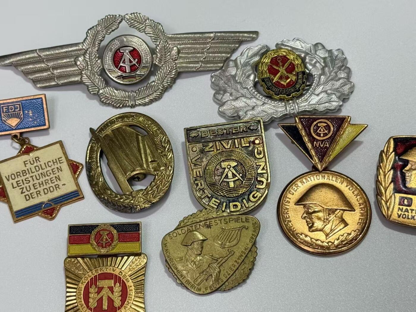 韵星假日精品2025秋季军品类拍卖会-- Rimey Holidays Boutique 2025 Autumn Militaria Sale 民主德国勋赏一组（准军事组织帽徽 空军帽徽 军版金级体能章 优秀士兵）