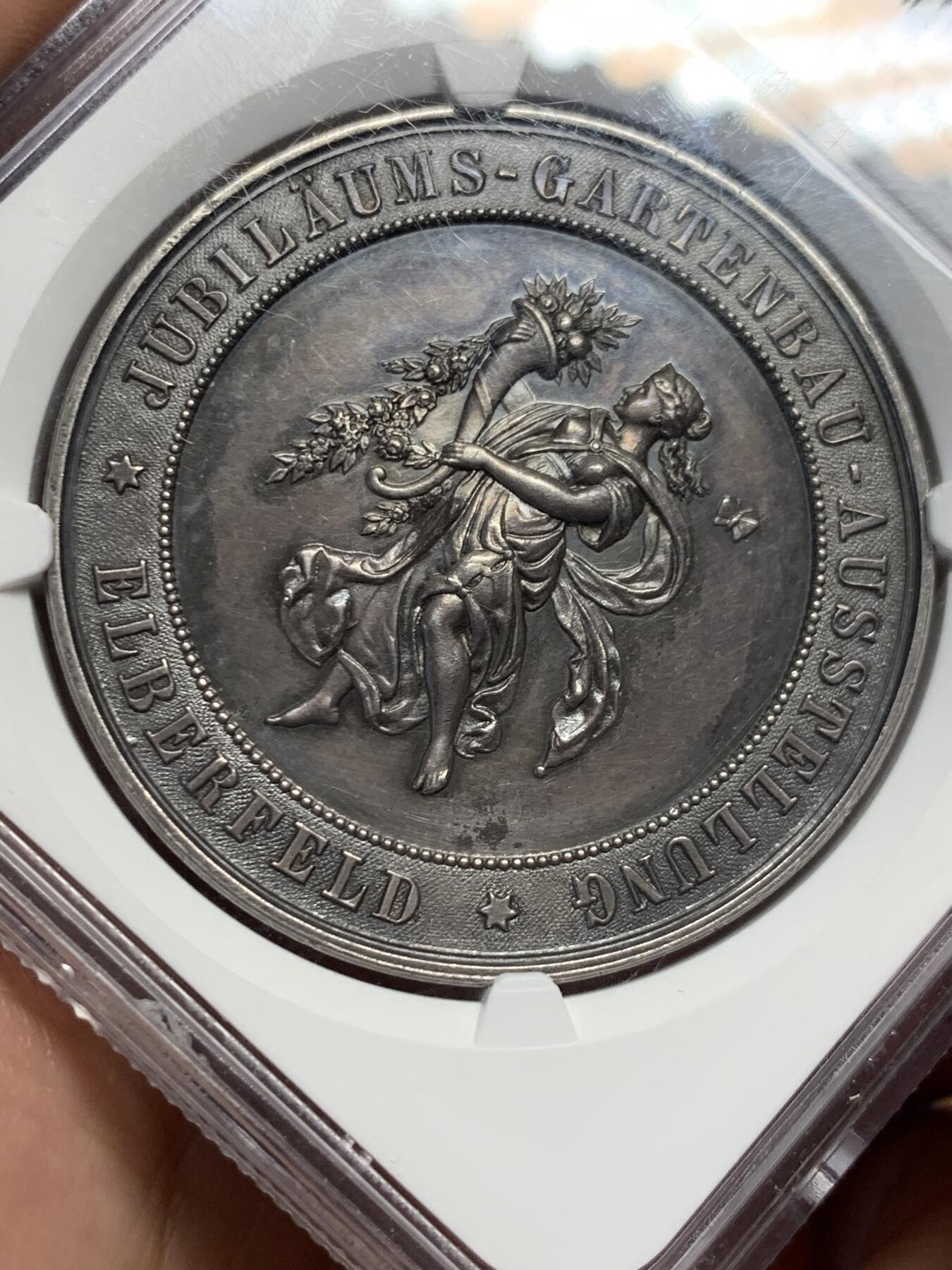 《竞宝斋》第434场 周日，周一2场连拍 （全场包邮） NGC MS61 德国1893年园艺博览会大银章，41mm大规格，少女衣纹流畅丰美，花卉蔬果刻画精细，工艺精湛。黑彩老包浆非常漂亮，实物状态极佳，严重低评