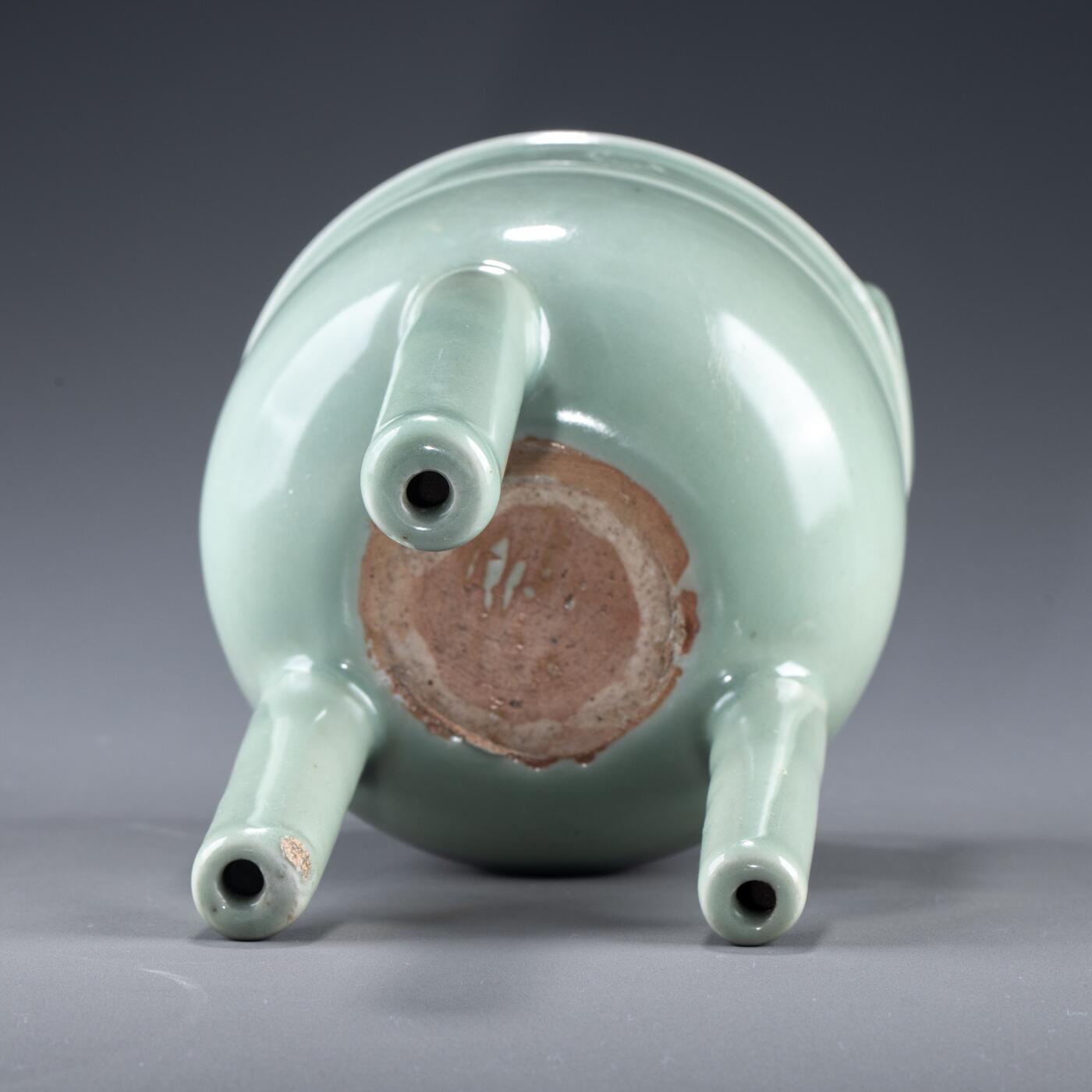 日本大阪雅和auction 2025金秋競賣會第一期 南宋 龍泉窯葱管三足鼎 尺寸:W:13 H:20cm 備註:盒付   此件南宋龍泉窯青釉鼎式爐，通體施粉青釉，色澤清潤如玉，呈柔和青翠之調，光潔內斂，頗具玉質之美。爐身圓腹，雙耳高聳上揚，三足中空、形似蔥管，挺拔穩健。整體比例勻稱，線條簡潔流暢，盡顯宋代器物的典雅之風。此式承襲青銅禮鼎造型，融祭器莊嚴與文房雅玩於一體，既可焚香，又具觀賞之趣，充分體現宋人「以瓷擬玉」之審美理想與高潔意趣。