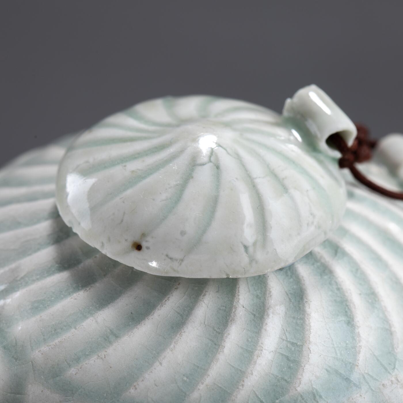 日本大阪雅和auction 2025金秋競賣會第一期 宋 湖田窯執壺 尺寸:W:11 H:9cm 備註:盒付   本器為宋代湖田窯所製執壺，通體施青白釉，釉色清潤柔和，溫潤如玉。壺身與蓋飾以螺旋剔刻紋，刀工流暢，層次分明，體現極高工藝水準。壺形端正，流口、把手與蓋鈕比例協調，實用與美觀兼具。此壺保存完好，為古瓷愛好者與茶道收藏者不可多得之佳品。