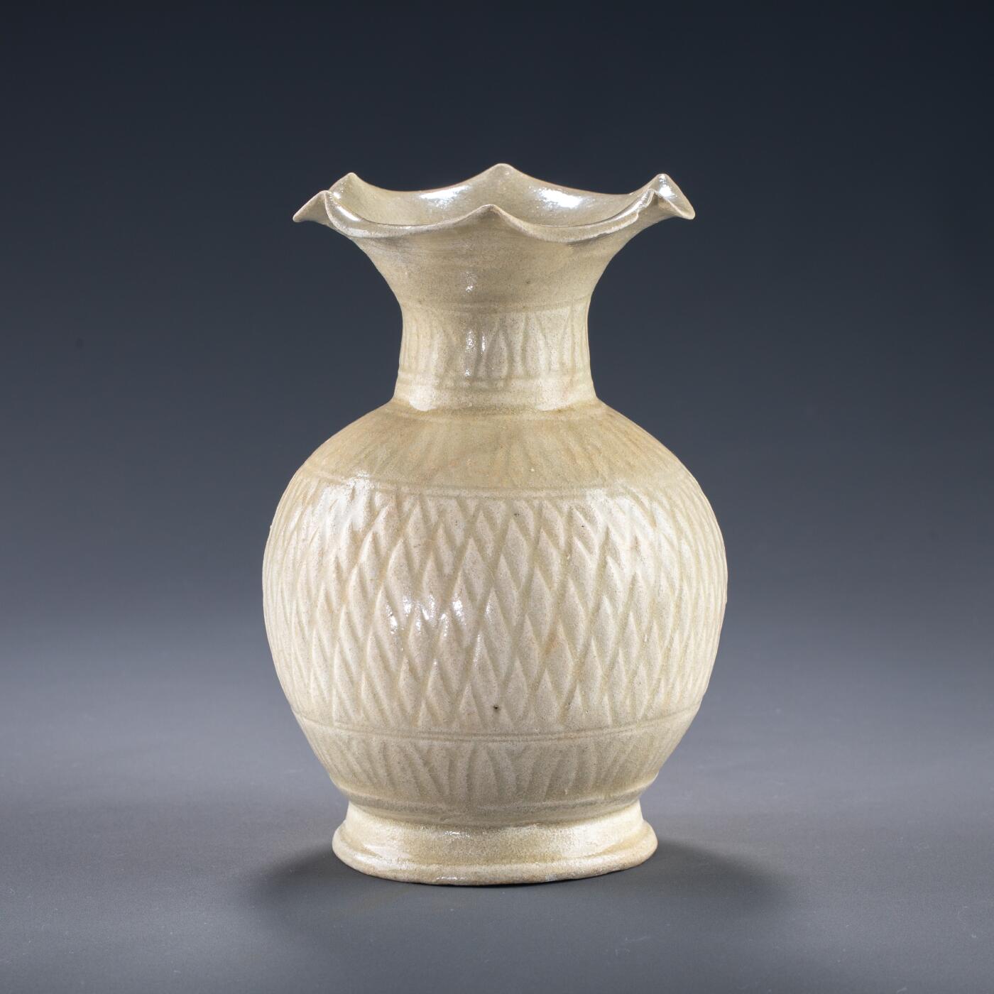 日本大阪雅和auction 2025金秋競賣會第一期 宋 景德鎮窯花口瓶 尺寸:D:11 H:18cm 備註:盒付   本品為宋代景德鎮窯所製影青瓷瓶，胎質細膩，釉色清潤淡雅，瓶身飾以規整的菱形紋，刻畫細緻，器形優雅大方。瓶口外撇如花瓣綻放，極富裝飾性與藝術美感。影青釉為宋代瓷器代表性風格之一，於光影之下更顯晶瑩溫潤，展現出高超的制瓷工藝與審美品味。保存狀況良好，收藏與陳設皆宜，誠為宋瓷愛好者珍貴之選。