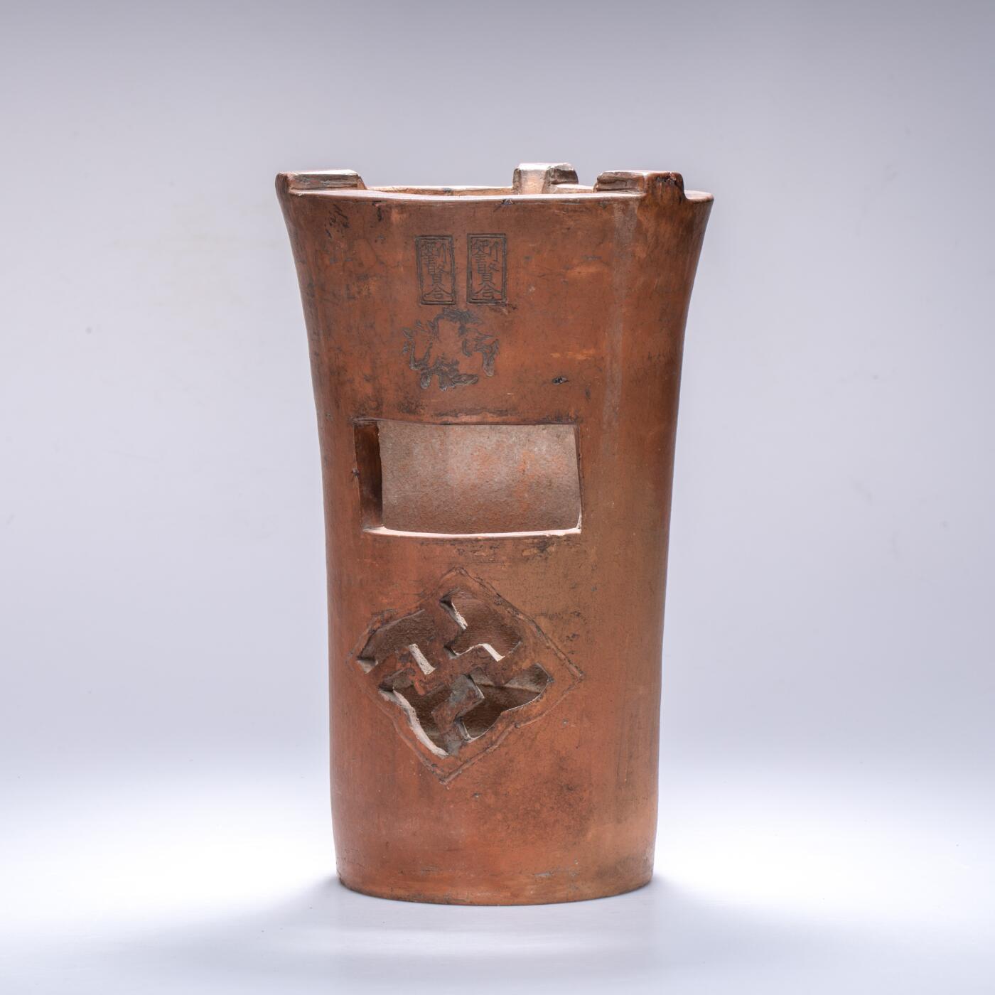 日本大阪雅和auction 2025金秋競賣會第一期 清 劉賢合款涼爐 尺寸:W:16 H:25cm 備註:此件紅泥涼爐，通體呈溫潤赤褐色，質地堅實細膩。爐身上部微敞，線條挺拔簡練，正面鏤空幾何紋飾，造型古樸而富有裝飾性。爐面刻「劉賢合」款，字體工整，彰顯製作者之巧思與自信。整體造型端莊穩重，器壁厚實，既具實用功能，又有極高的藝術觀賞價值，乃集工藝與美感於一體之紅泥佳作。