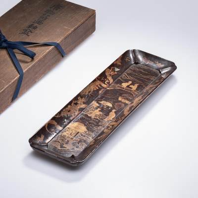 日本大阪雅和auction 2025金秋競賣會第一期 - 明 唐物箔畫軸盆 尺寸:L:40 W:11.5cm 備註:木箱   此件唐物箔畫軸盆，形制修長方正，盆壁微斜，邊角處理流暢自然。通體施黑漆為地，以金箔繪山水人物，構圖精緻，筆意生動，層次分明。畫面中亭臺樓閣、樹石人物交錯，盡顯東洋漆藝之細膩與雅趣。保存原木盒，墨書題識清晰。整器古樸高雅，為觀賞與實用兼備之珍品，亦展現出唐物工藝的獨特風韻。