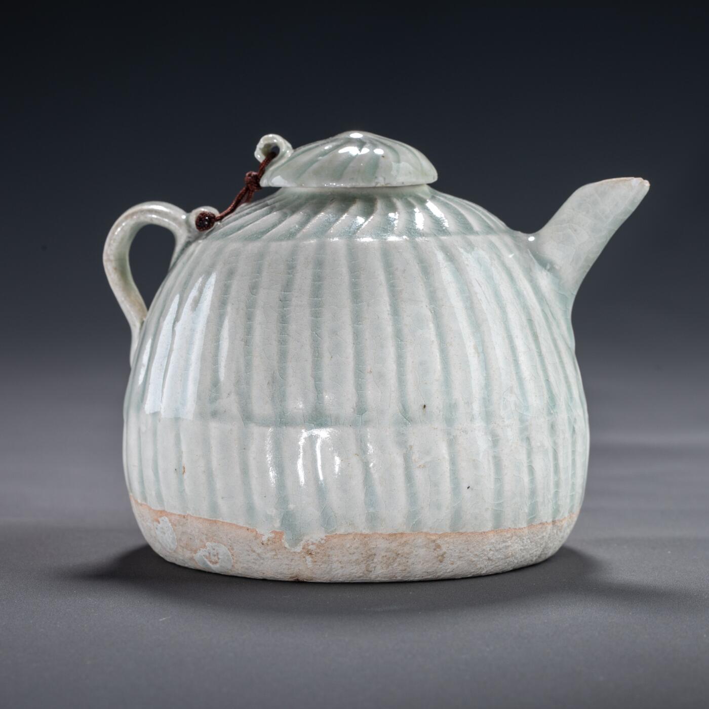 日本大阪雅和auction 2025金秋競賣會第一期 宋 湖田窯執壺 尺寸:W:11 H:9cm 備註:盒付   本器為宋代湖田窯所製執壺，通體施青白釉，釉色清潤柔和，溫潤如玉。壺身與蓋飾以螺旋剔刻紋，刀工流暢，層次分明，體現極高工藝水準。壺形端正，流口、把手與蓋鈕比例協調，實用與美觀兼具。此壺保存完好，為古瓷愛好者與茶道收藏者不可多得之佳品。