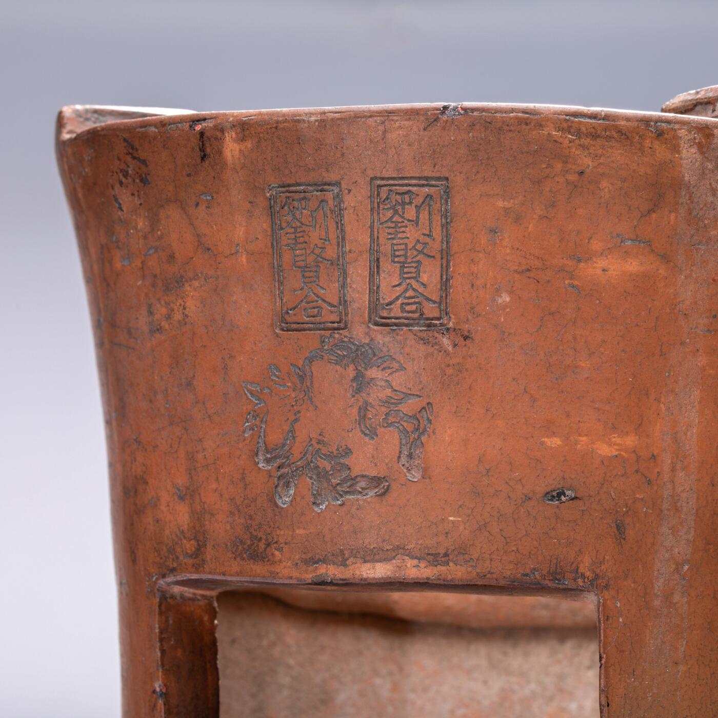 日本大阪雅和auction 2025金秋競賣會第一期 清 劉賢合款涼爐 尺寸:W:16 H:25cm 備註:此件紅泥涼爐，通體呈溫潤赤褐色，質地堅實細膩。爐身上部微敞，線條挺拔簡練，正面鏤空幾何紋飾，造型古樸而富有裝飾性。爐面刻「劉賢合」款，字體工整，彰顯製作者之巧思與自信。整體造型端莊穩重，器壁厚實，既具實用功能，又有極高的藝術觀賞價值，乃集工藝與美感於一體之紅泥佳作。