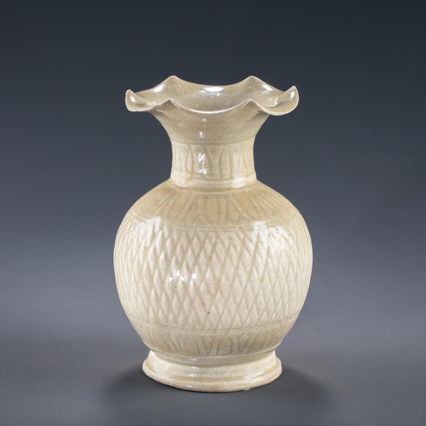 日本大阪雅和auction 2025金秋競賣會第一期 宋 景德鎮窯花口瓶 尺寸:D:11 H:18cm 備註:盒付   本品為宋代景德鎮窯所製影青瓷瓶，胎質細膩，釉色清潤淡雅，瓶身飾以規整的菱形紋，刻畫細緻，器形優雅大方。瓶口外撇如花瓣綻放，極富裝飾性與藝術美感。影青釉為宋代瓷器代表性風格之一，於光影之下更顯晶瑩溫潤，展現出高超的制瓷工藝與審美品味。保存狀況良好，收藏與陳設皆宜，誠為宋瓷愛好者珍貴之選。