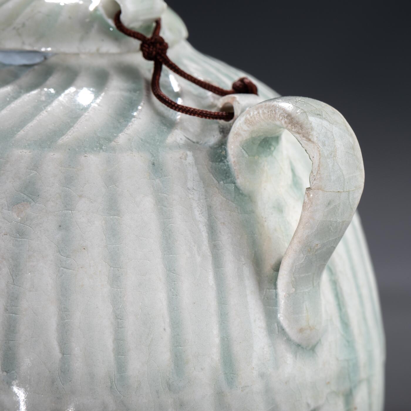 日本大阪雅和auction 2025金秋競賣會第一期 宋 湖田窯執壺 尺寸:W:11 H:9cm 備註:盒付   本器為宋代湖田窯所製執壺，通體施青白釉，釉色清潤柔和，溫潤如玉。壺身與蓋飾以螺旋剔刻紋，刀工流暢，層次分明，體現極高工藝水準。壺形端正，流口、把手與蓋鈕比例協調，實用與美觀兼具。此壺保存完好，為古瓷愛好者與茶道收藏者不可多得之佳品。