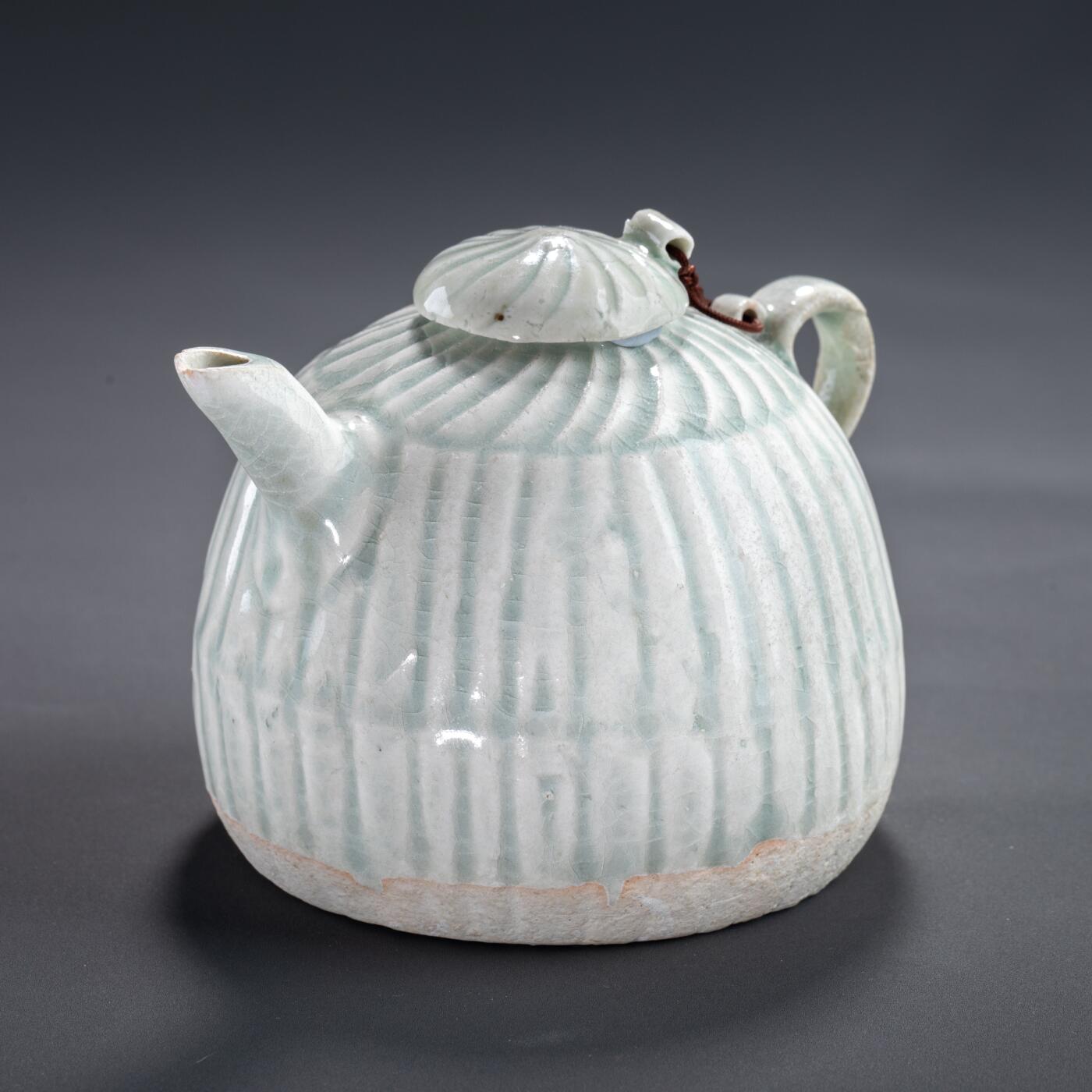 日本大阪雅和auction 2025金秋競賣會第一期 宋 湖田窯執壺 尺寸:W:11 H:9cm 備註:盒付   本器為宋代湖田窯所製執壺，通體施青白釉，釉色清潤柔和，溫潤如玉。壺身與蓋飾以螺旋剔刻紋，刀工流暢，層次分明，體現極高工藝水準。壺形端正，流口、把手與蓋鈕比例協調，實用與美觀兼具。此壺保存完好，為古瓷愛好者與茶道收藏者不可多得之佳品。