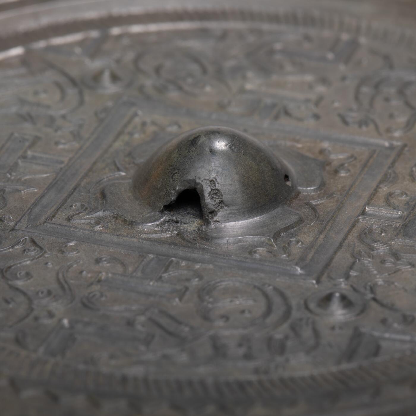 日本大阪雅和auction 2025金秋競賣會第一期 漢 走獸紋規矩鏡 尺寸:D:14cm 備註:盒付   此面漢代走獸紋規矩鏡，鏡體渾圓厚重，通體黑漆古包漿，色澤沉潤柔和，鏡背以精細線條鑄出走獸紋飾，或奔或躍，神態生動，間以幾何規矩紋相間佈局，構圖嚴謹而富節奏感。鏡紐高起，形制端正，邊廓勻整，展現漢代青銅鏡工藝的成熟與規範之美。此類鏡多寓意驅邪護身、吉祥長安，包漿溫潤，光澤深邃，鏡面保存完好，實屬難得。其兼具實用與審美價值，彰顯漢代金屬藝術的莊重典