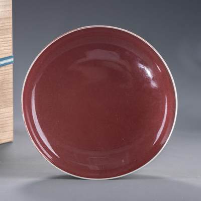 日本大阪雅和auction 2025金秋競賣會第一期 - 清康熙 大明成化年制款紅釉大盤 尺寸:D:20.5 H:4.5cm 備註:木箱   此件清康熙紅釉大盤，造型端莊圓潤，胎體厚實細膩。通體施紅釉，色澤深沉如寶石，釉面光亮瑩潤，呈現溫潤柔和之美。盤內外釉色勻淨無瑕，光影流轉間更顯層次變化。圈足修整規整，底書「大明成化年制」六字款，為康熙時期仿成化名品之代表。康熙紅釉燒造技藝精湛，釉質與火候掌握極為嚴謹。此盤整體氣度高雅，釉色端麗雋永，集實用與觀賞於一