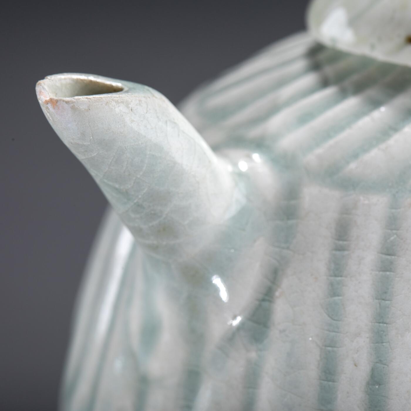 日本大阪雅和auction 2025金秋競賣會第一期 宋 湖田窯執壺 尺寸:W:11 H:9cm 備註:盒付   本器為宋代湖田窯所製執壺，通體施青白釉，釉色清潤柔和，溫潤如玉。壺身與蓋飾以螺旋剔刻紋，刀工流暢，層次分明，體現極高工藝水準。壺形端正，流口、把手與蓋鈕比例協調，實用與美觀兼具。此壺保存完好，為古瓷愛好者與茶道收藏者不可多得之佳品。