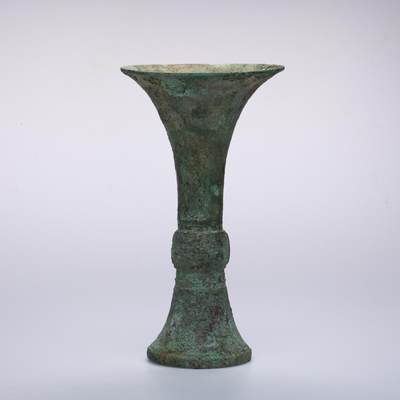 日本大阪雅和auction 2025金秋競賣會第一期 - 商 饕餮紋花觚 尺寸:W:14.5 H:25.5cm 備註:商代饕餮紋花觚，通體造型高峻挺拔，線條勻稱流暢，腹部微鼓，頸部修長，口沿外撇，圈足穩健。全器以精緻的饕餮紋為主紋，繁而不亂，層次分明，展現出商代青銅藝術的莊嚴與神祕。花紋間飾以雷紋、夔龍及細密的幾何紋飾，刀痕遒勁，鑄工嚴謹。整器包漿古潤，青銅色澤沉靜雅緻，氣韻雄渾，威嚴中蘊含典雅之美。此觚不僅為祭祀禮器之代表，亦體現了商人敬天重禮的信仰與