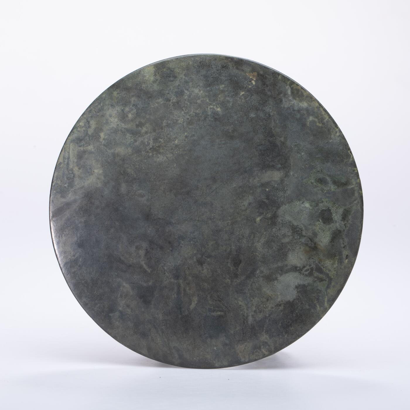 日本大阪雅和auction 2025金秋競賣會第一期 漢 走獸紋規矩鏡 尺寸:D:14cm 備註:盒付   此面漢代走獸紋規矩鏡，鏡體渾圓厚重，通體黑漆古包漿，色澤沉潤柔和，鏡背以精細線條鑄出走獸紋飾，或奔或躍，神態生動，間以幾何規矩紋相間佈局，構圖嚴謹而富節奏感。鏡紐高起，形制端正，邊廓勻整，展現漢代青銅鏡工藝的成熟與規範之美。此類鏡多寓意驅邪護身、吉祥長安，包漿溫潤，光澤深邃，鏡面保存完好，實屬難得。其兼具實用與審美價值，彰顯漢代金屬藝術的莊重典