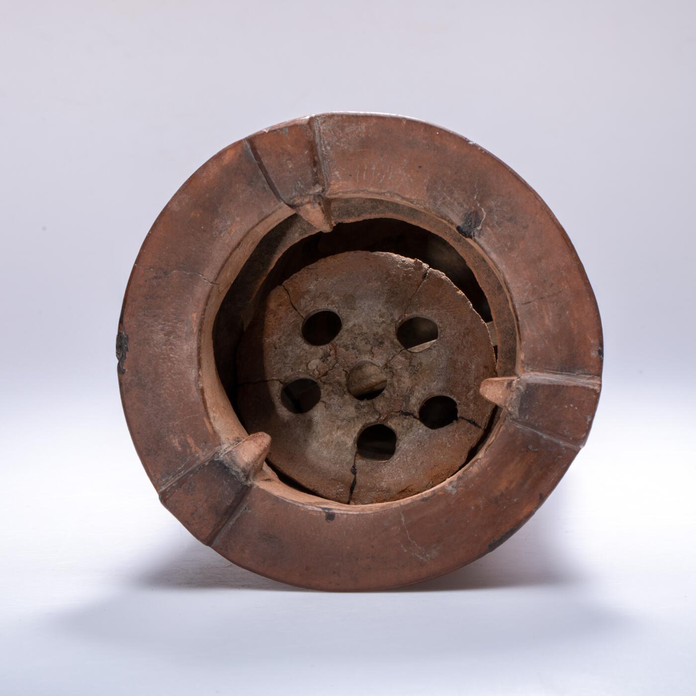 日本大阪雅和auction 2025金秋競賣會第一期 清 劉賢合款涼爐 尺寸:W:16 H:25cm 備註:此件紅泥涼爐，通體呈溫潤赤褐色，質地堅實細膩。爐身上部微敞，線條挺拔簡練，正面鏤空幾何紋飾，造型古樸而富有裝飾性。爐面刻「劉賢合」款，字體工整，彰顯製作者之巧思與自信。整體造型端莊穩重，器壁厚實，既具實用功能，又有極高的藝術觀賞價值，乃集工藝與美感於一體之紅泥佳作。