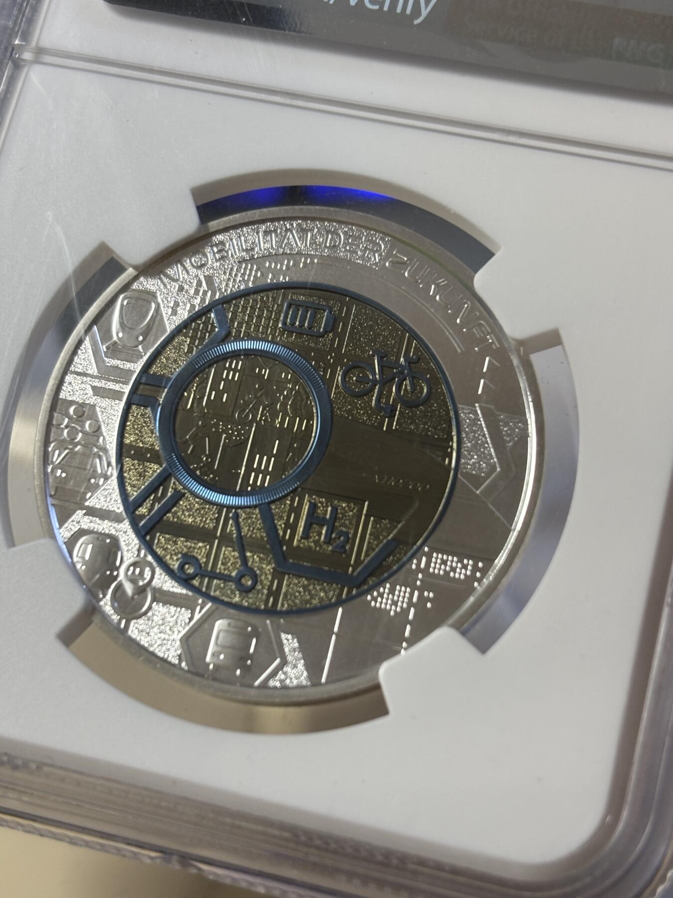 第181期拍卖 获奖奥地利2021年银铌双金属系列智能交通25欧银币NGC-MS70首无盒证书，2023年度克劳斯最佳双金属币面值:25欧元，金属:900银/998铌，重量:9/6.5克，直径:35毫米，发行：65000枚