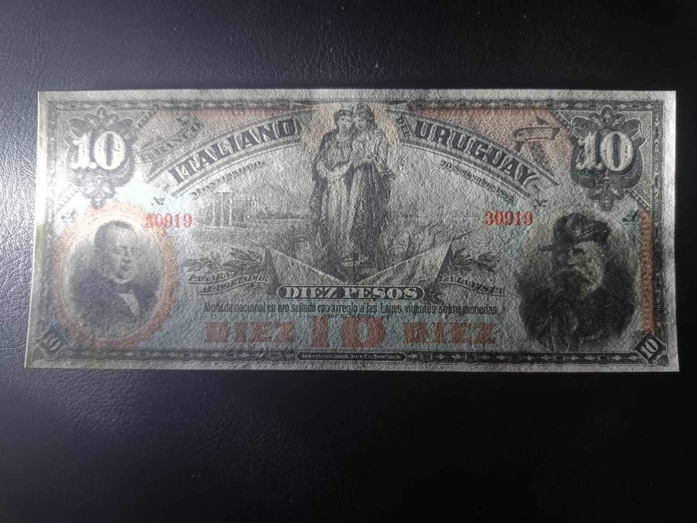 2025十一月第二期，总第200期 乌拉圭意大利银行1887年10比索UNC有针孔无47，极稀有的乌拉圭外资银行品种，正面是时任乌拉圭总统的奥多涅斯将军和发现新大陆的哥伦布，而背面是女性肖像坐在象征工业的铁砧飞轮和棉纱包中，背景是飞驰的火车