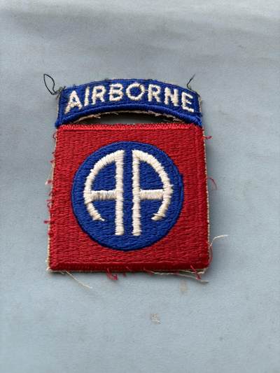 盛世勋华——号角文化勋章邮票专场拍卖第287期 - 美国第82空降师臂章，（二战～朝鲜战争时期版本）美国第82空降师是美军历史最久、战力最强的现役空降部队，有“全美师”“美国战略铁拳”之称，具备全球18小时快速部署能力，1942年8月改编为美军首个空降师，参与西西里战役，诺曼底登陆，市场花园行动，阿登战役，1952年82空降师187空降团作为预备队参与朝鲜战争上甘岭战役，却被志愿军依托坑道工事和顽强意志击退，最终未能突破志愿军防线