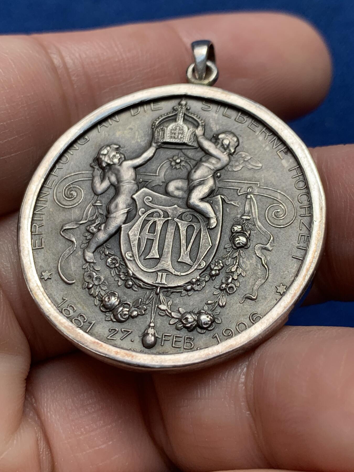 《竞宝斋》第436场 周日，周一2场连拍 （全场包邮） 1906年德国普鲁士威廉二世银婚25周年纪念章吊坠，皇帝威廉二世和皇后奥古斯特维多利亚半身像/两个天使举着皇冠，下方威廉二世花押签名，1881-1906年。整体采用镶嵌工艺接做成了吊坠，内章为950银，外圈吊坠为925银，直径约35毫米，总重约：18.7克。名誉品种，可直接佩戴。