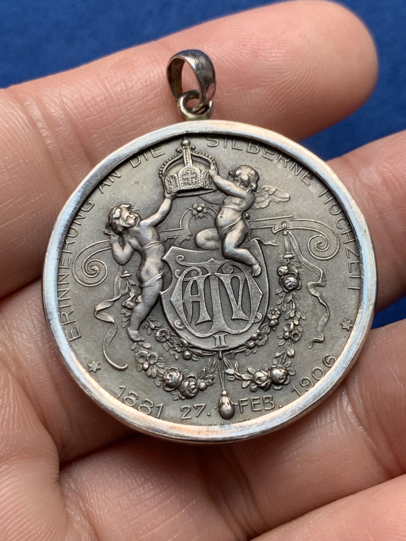 《竞宝斋》第436场 周日，周一2场连拍 （全场包邮） 1906年德国普鲁士威廉二世银婚25周年纪念章吊坠，皇帝威廉二世和皇后奥古斯特维多利亚半身像/两个天使举着皇冠，下方威廉二世花押签名，1881-1906年。整体采用镶嵌工艺接做成了吊坠，内章为950银，外圈吊坠为925银，直径约35毫米，总重约：18.7克。名誉品种，可直接佩戴。