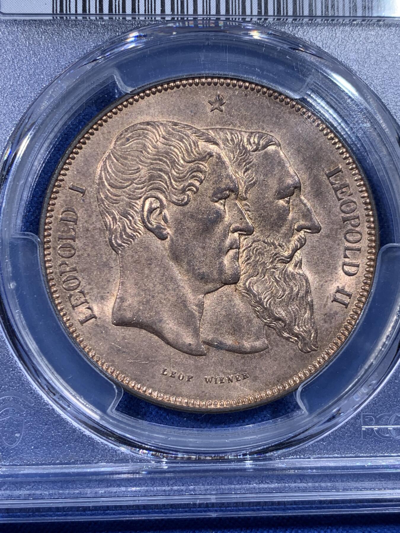 《竞宝斋》第436场 周日，周一2场连拍 （全场包邮） PCGS MS64RB 比利时1880年独立50周年5法郎型铜币 红棕（RB）描述少见。正面是自由女神手持宪法倚靠象征君权的狮子，背面是利奥波德一世二世双头像。珍惜币目录收藏，铜质自然，边缘完整。经典品种，上乘质量，可藏之物。