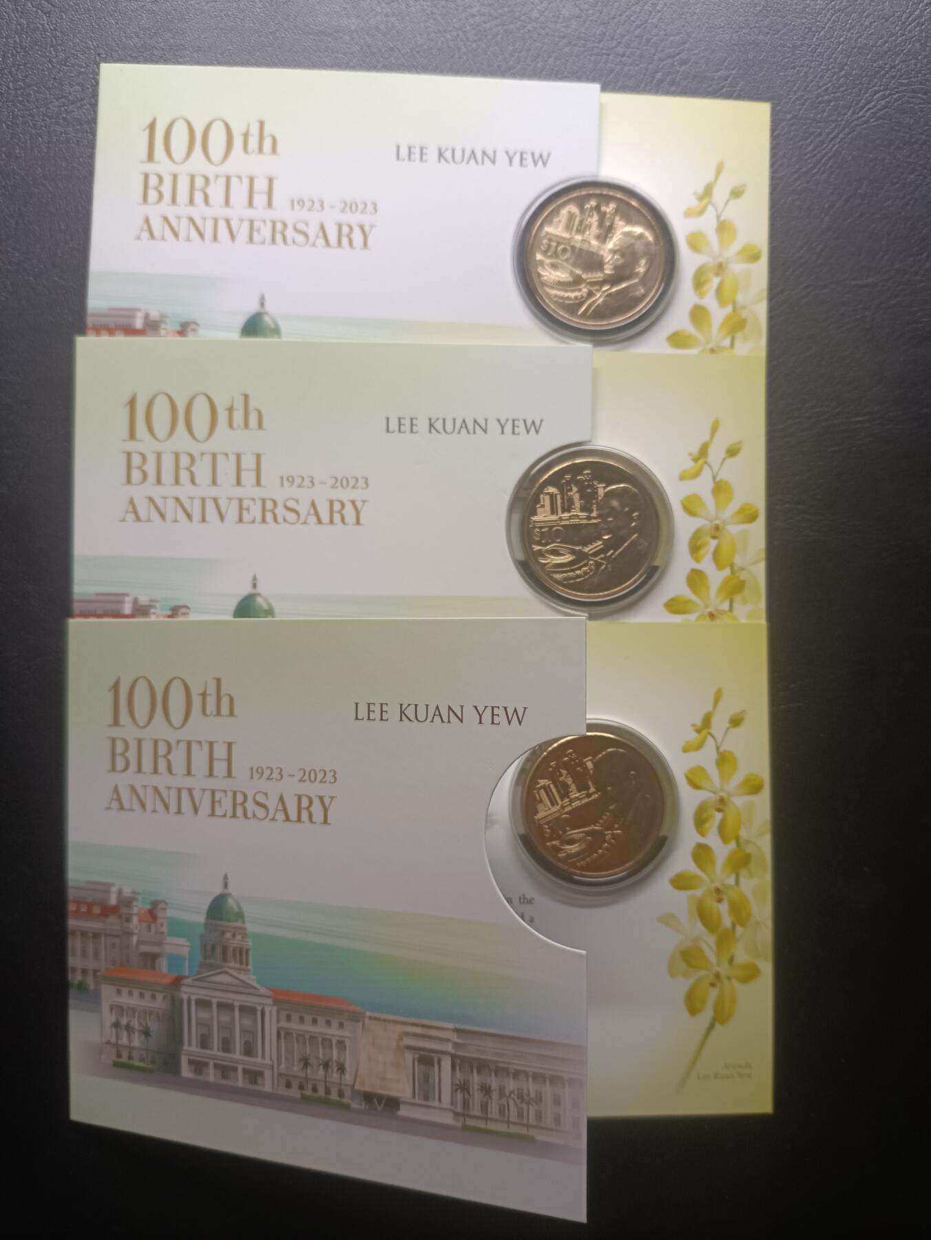 2025十一月第三期，总201期 【雨】新加坡2023年国父李光耀诞辰100周年铜制10元纪念币带册全新批量三枚，国会大楼和国花胡姬花