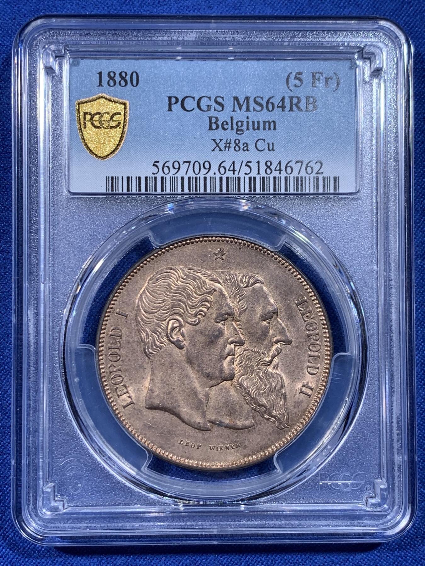《竞宝斋》第436场 周日，周一2场连拍 （全场包邮） PCGS MS64RB 比利时1880年独立50周年5法郎型铜币 红棕（RB）描述少见。正面是自由女神手持宪法倚靠象征君权的狮子，背面是利奥波德一世二世双头像。珍惜币目录收藏，铜质自然，边缘完整。经典品种，上乘质量，可藏之物。